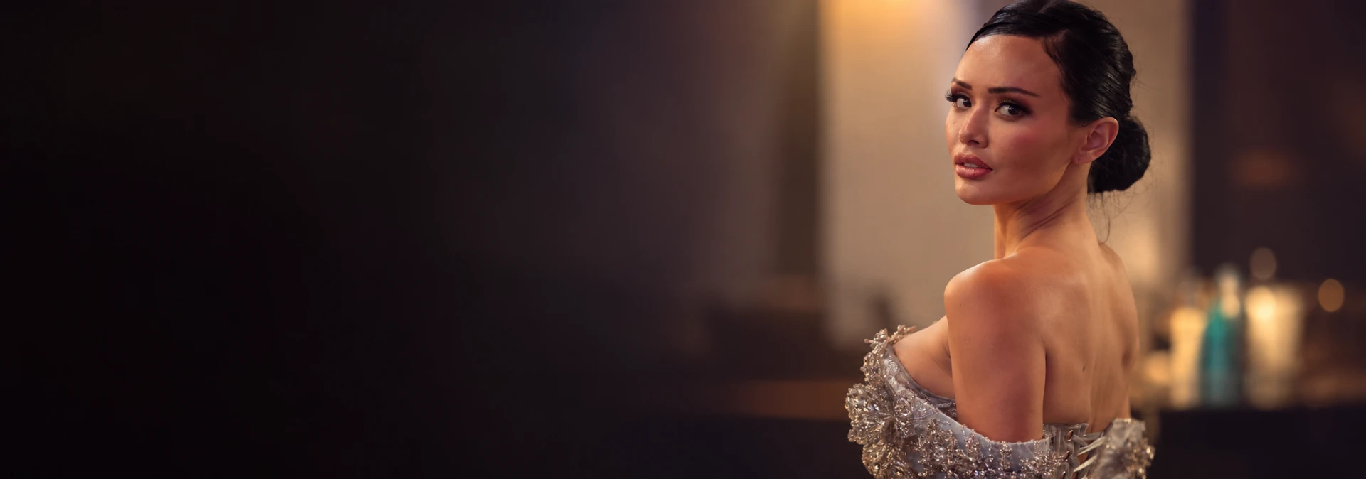 Model in a silver couture gown looking over her shoulder.